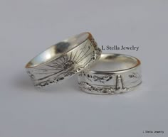 two silver rings with designs on them sitting next to each other in front of a white background