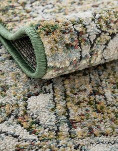 a rug with green and white colors on the floor, closeup view from above