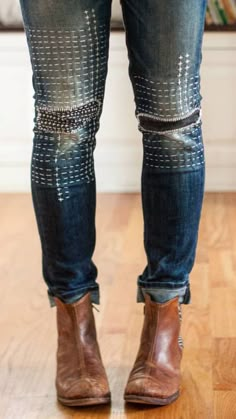 the legs and ankles of a person wearing jeans with studded knee patches on them