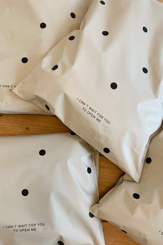 three pillows with black dots on them sitting on a wooden floor next to each other