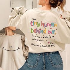 Dear Tiny Human Behind Me Sweatshirt, Teacher Sweatshirt, Inspirational Teacher Gift, Teacher Appreciation, New Teacher Shirt, Cute Teacher Thank you so much for taking the time to browse my shop. Please feel free to reach out if you have any questions before or after purchasing.  💖 🎨Warning: On products with a print chart in the listing, metallic print colors are printed as matte.✌✨ We design and cut each graphic out with a soft touch, use matte vinyl and a heat press. The result will last fo Meaningful Text Print Crew Neck Tops, Inspirational White Crew Neck Sweatshirt, White Long Sleeve Sweatshirt With Funny Text, White Long Sleeve Tops With Funny Text, Inspirational Crew Neck Top With Funny Text, Inspirational Crew Neck Tops With Letter Print, Inspirational Relaxed Fit Long Sleeve Top, Inspirational Long Sleeve Relaxed Fit Top, Inspirational Cotton Graphic Sweatshirt