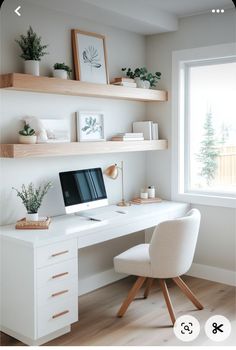 a desk with a computer on top of it and some shelves above the desk, along with potted plants