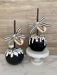 two black and white cake pops decorated with ribbons