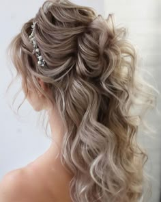 the back of a woman's head with curly hair and pearls in her hair