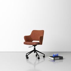 an office chair sitting on top of a white floor next to a pile of books