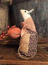 a stuffed mouse sitting on top of a wooden table next to a pumpkin and other items