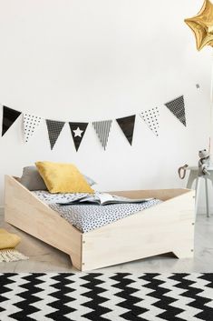 a bed sitting on top of a white floor next to a black and white rug