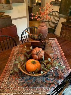 a bowl filled with pumpkins sitting on top of a wooden table