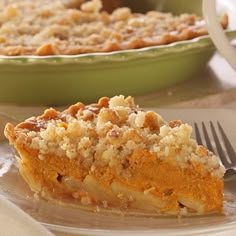 a piece of pie sitting on top of a white plate next to a green bowl