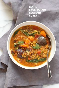 lentil, sweet potato and eggplant curry in a white bowl with a spoon