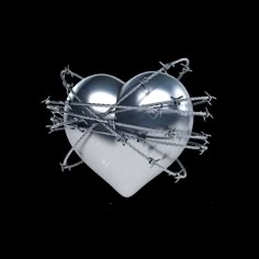 a heart shaped object with barbed wire on it's sides, against a black background