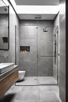 Modern bathroom with glass shower enclosure, floating vanity, and gray tiles. Tiny Wet Room, Clever Decor