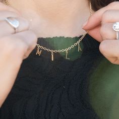 a woman wearing a necklace with letters on it