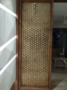 an intricately designed wooden door in the corner of a room with light coming through it