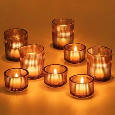 six glass candles sitting on top of a table