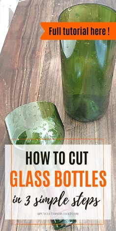 a green glass bottle sitting on top of a wooden table next to a cup filled with liquid