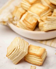 a plate full of short crackers sitting on top of a counter next to a bowl