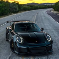 a black sports car is parked on the side of the road