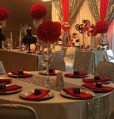 the table is set with silver and red decorations