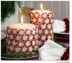 two candles sitting on top of plates with napkins