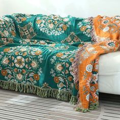 a couch covered in a green and orange blanket