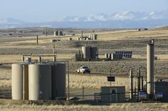 an oil refinery in the middle of nowhere with mountains in the backgrouds