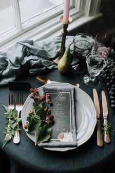 the table is set with an elegant menu and place settings for two people to eat