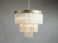 a chandelier hanging from a ceiling in a room with concrete walls and flooring