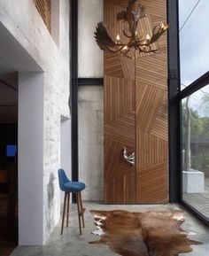 a living room with a chair and wooden door