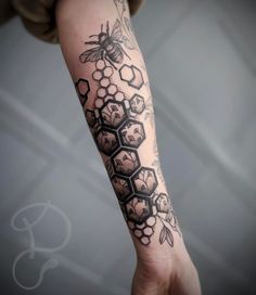 a woman's arm with honeycombs and flowers tattoo on the left forearm