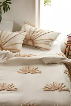 a bed with white sheets and decorative pillows