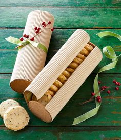 an open box of crackers next to a roll on a wooden table with ribbon