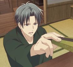 an anime character holding scissors in his hand while sitting at a table with another person behind him