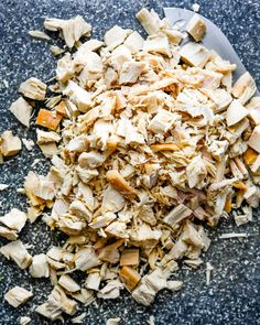 chopped chicken and carrots in a bowl on top of a granite counter with a spoon