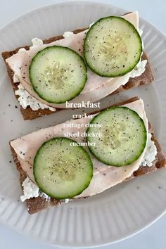 two slices of bread with cucumbers on them and the words breakfast written in english