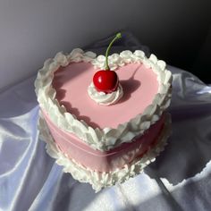 a heart shaped cake with a cherry on top