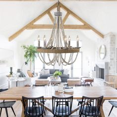 a chandelier hangs from the ceiling above a dining room table with black chairs