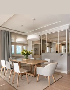 a dining room table with white chairs around it