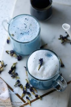 two mugs filled with liquid sitting on top of a table