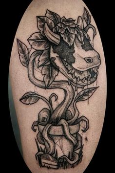 a black and white photo of a dragon with flowers on it's back leg