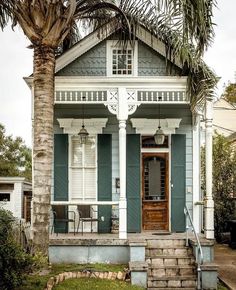 a house with blue shutters and palm trees