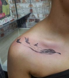 a woman with a tattoo on her shoulder that has birds flying through the sky and arrows coming out of it