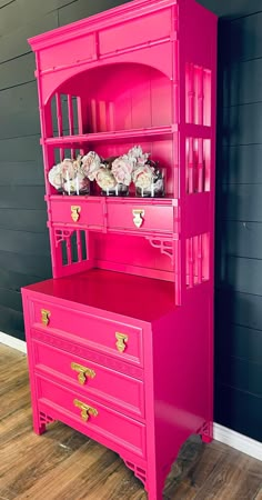 a pink dresser with flowers on top