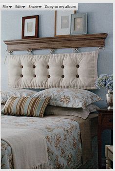 a bedroom with blue walls and white bedding, two framed pictures on the headboard