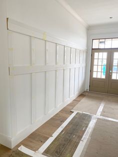 an empty room with white walls and wood flooring in the process of remodeling