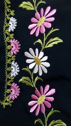 a black shirt with pink, white and green flowers embroidered on the back of it