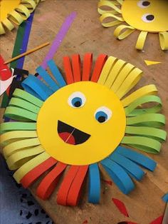 the paper lion is sitting on top of the wooden table next to scissors and paint