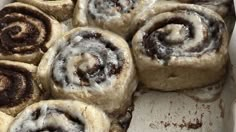 cinnamon rolls in a baking pan with icing on top