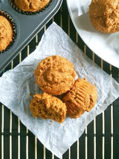 some muffins are sitting on a paper towel next to a muffin tin