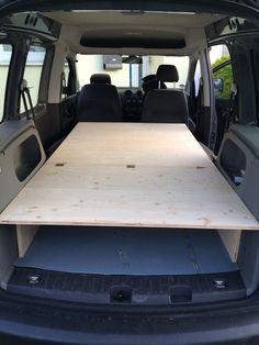 the back end of a van with a wooden table in it's cargo area